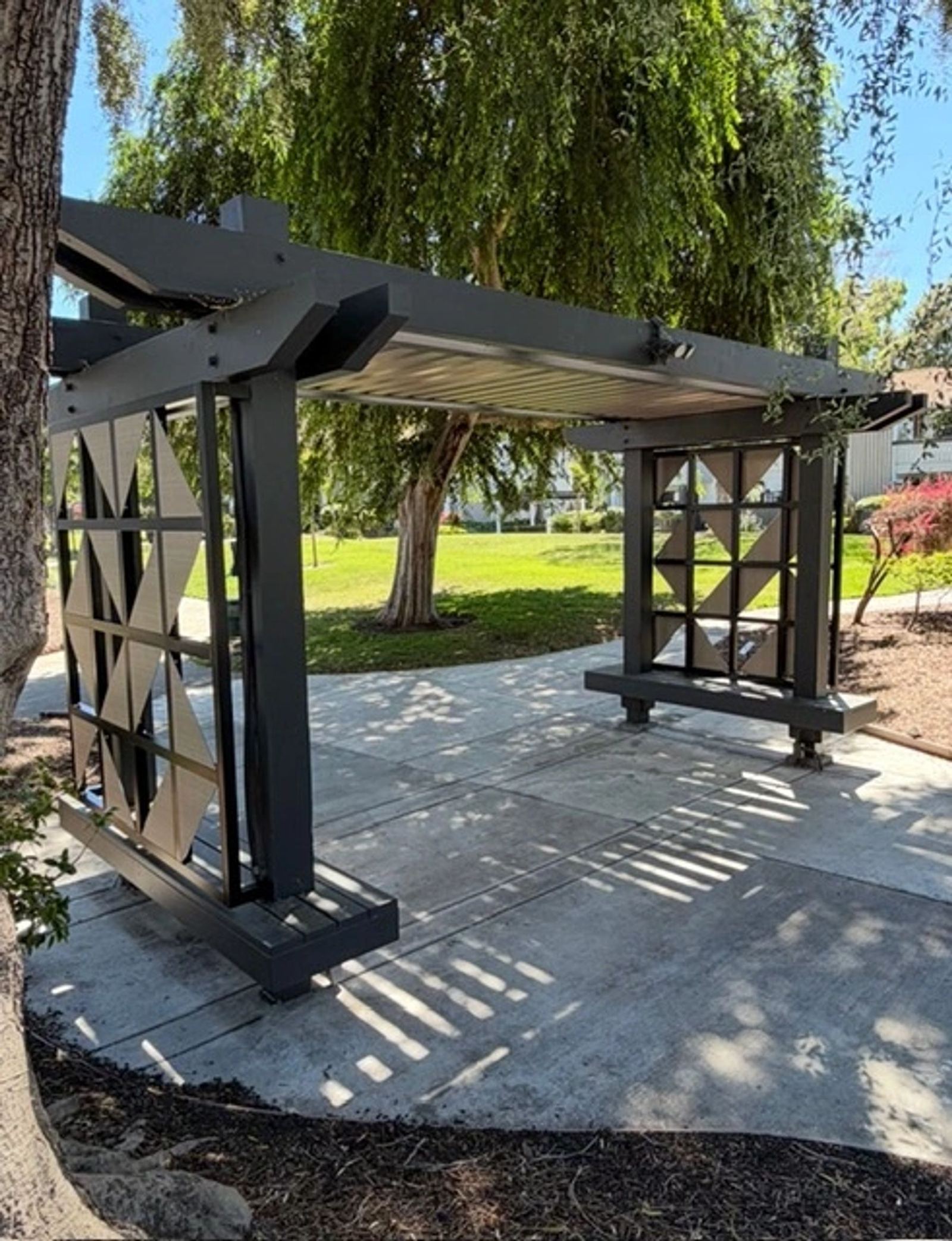 A custom steel trellis and pergola structure over a concrete patio, an ATR Welding fabrication