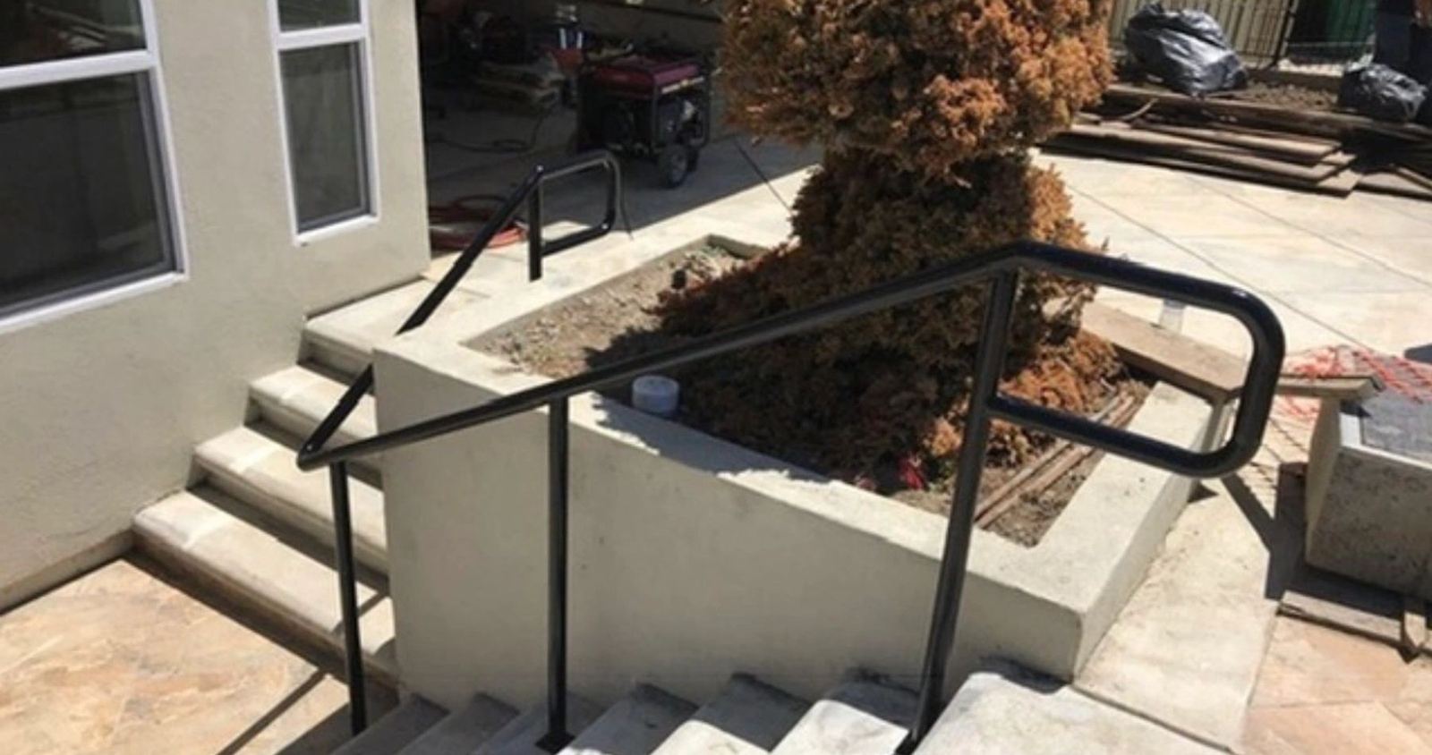 A black exterior handrail installed alongside steps, an ATR Welding installation