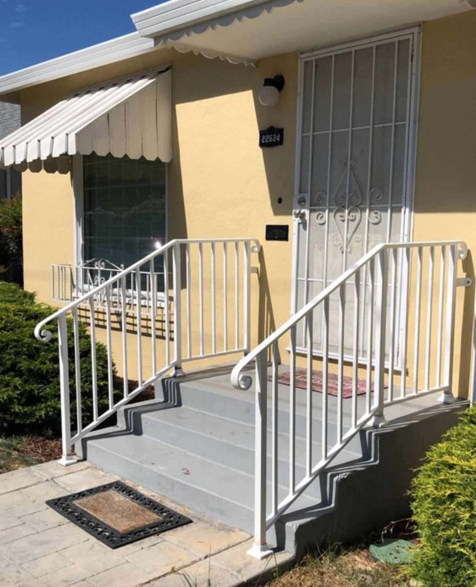 A white ornamental porch railing with scrollwork, an ATR Welding installation