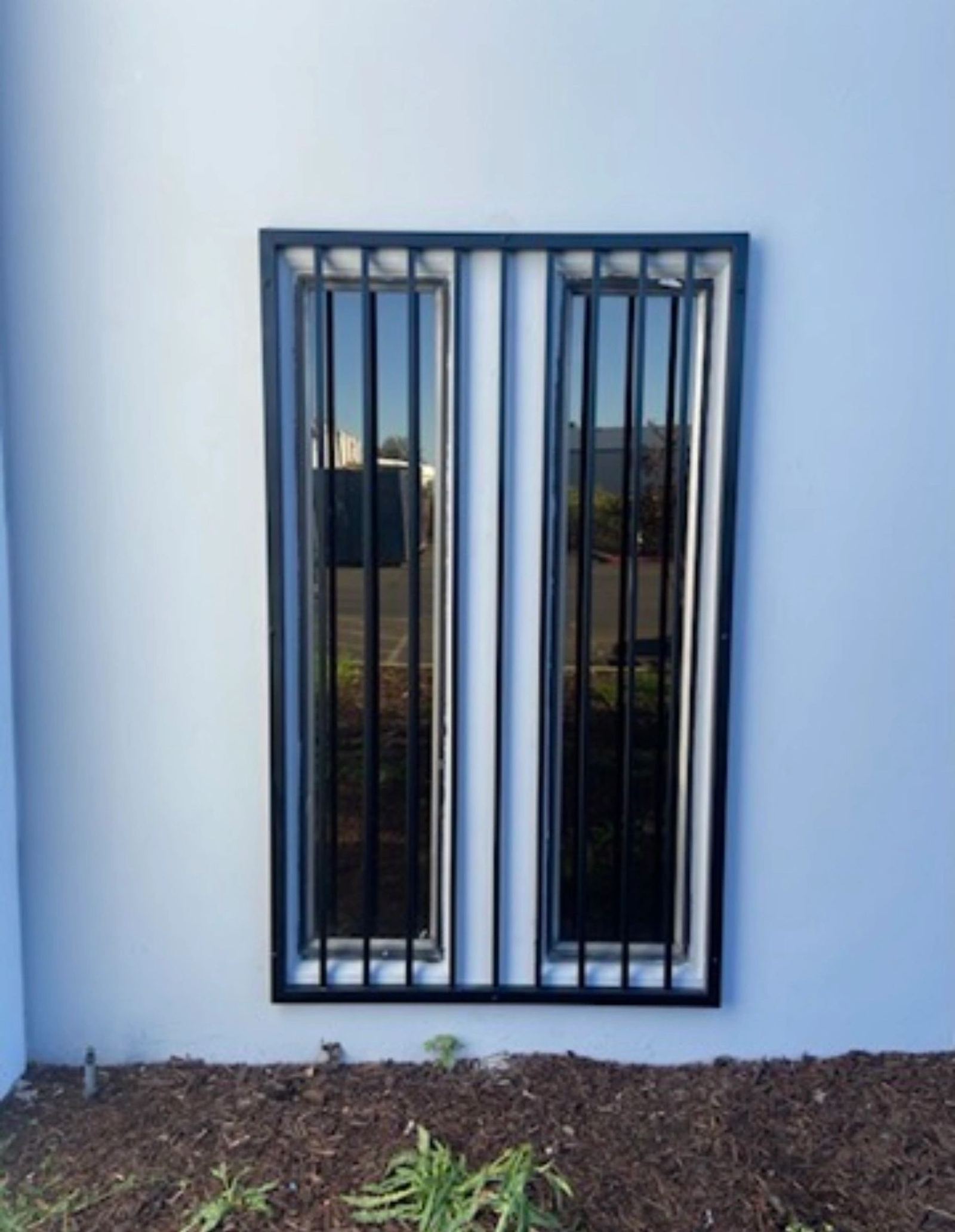 Black metal security bars fitted to a building window, an ATR Welding installation
